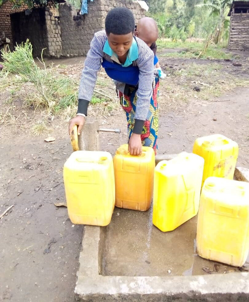 Une femme remplissant des bidons à l'une des pompes